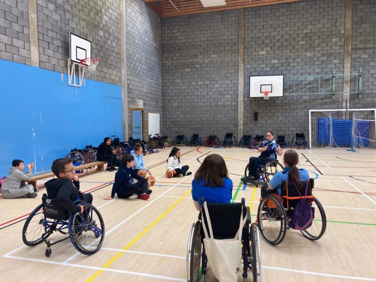 Young people in a sports hall sitting in wheelchairs