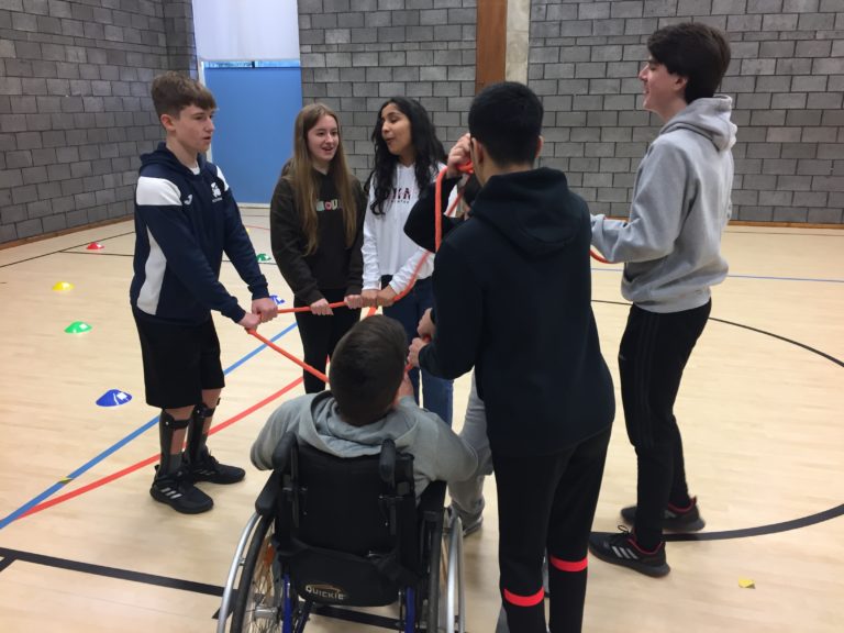 A group of young people in a sports hall talking