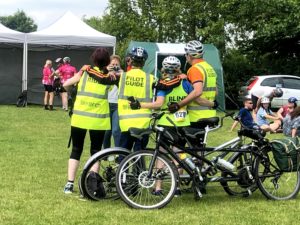 4 people with high vis jackets with arms around eachother