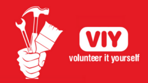 red background, white graphic of a hand holding a paintbrush, hammer and spanner. White text reads 'viy' and below 'volunteer it yourself/