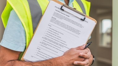 man in hi vis vest with clip board