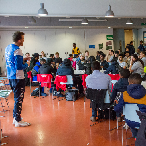 Man speaking to a group of people in a classroom setting
