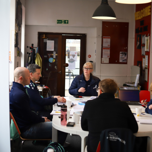 Group of adults sat around a table talking