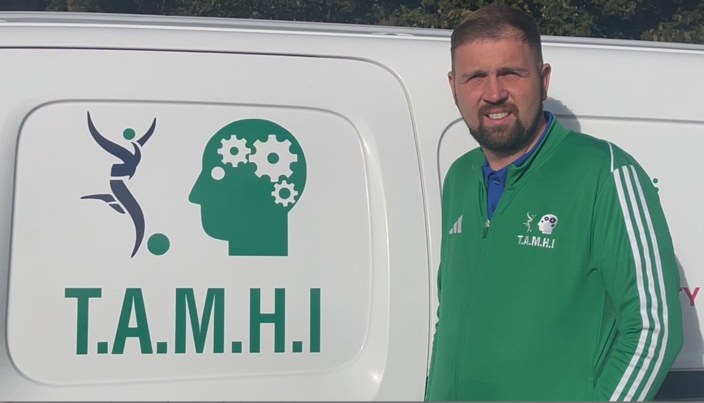 Joe from TAMHI leans on van