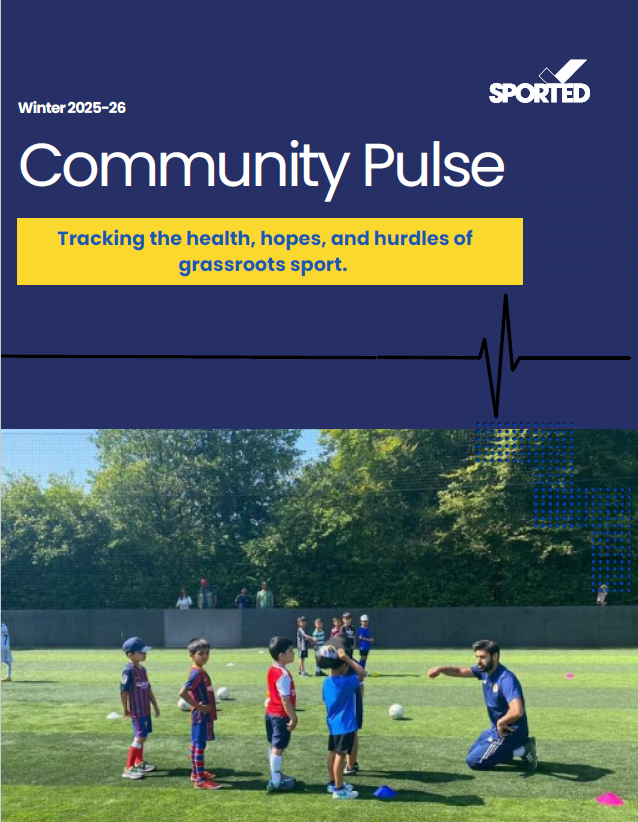 Half navy blue image with the writing Winter 2025-26 Community Pulse Tracking the health, hopes , and hurdles of grassroots sports. Underneath the text is a photo of young children with a football coach kneeling in front of them giving an instruction.