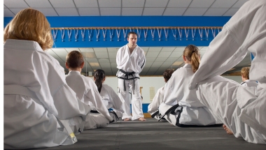 martial arts teacher speaking with pupils who are sitting down