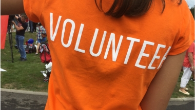 photo of a woman in an orange volunteer shirt