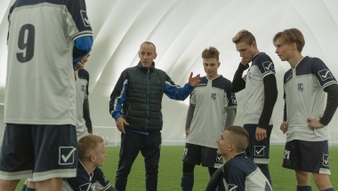 coach speaking with a football team/