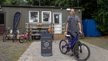 man with a bike standing in front of a building