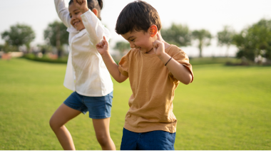 two children dancing in a park