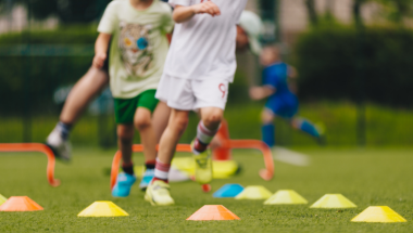 children running on astroturf with coloured cones