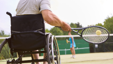 man playing wheelchair tennis on an outdoor court