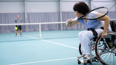 woman playing wheelchair tennis indoors