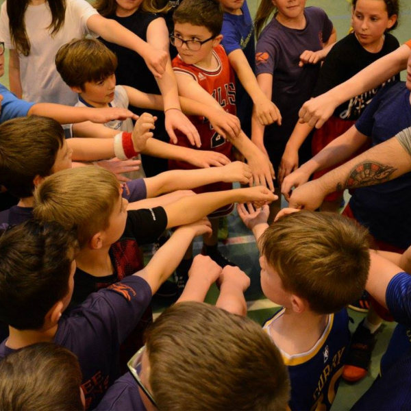 A group of young people with their hands in the middle