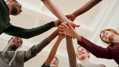 group of people with hands in the centre of the group